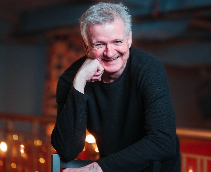 Pat Doyle Smiling while leaning on chair